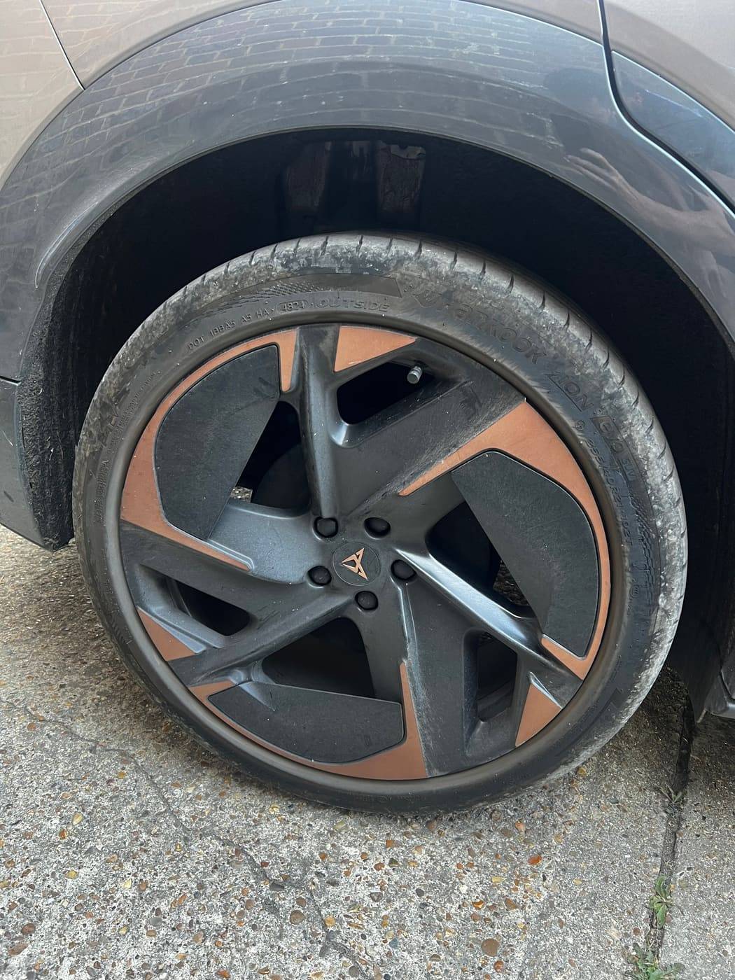 Copper alloy wheel before cleaning, road grime across the spokes