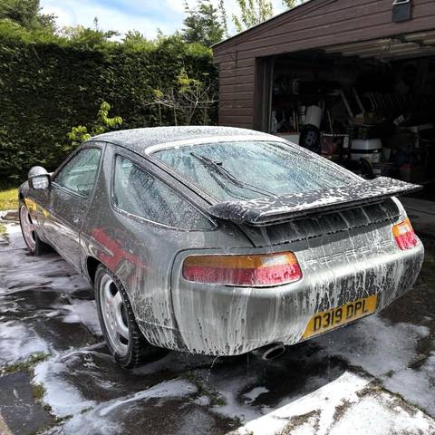 Classic Porsche 928 covered in snow foam