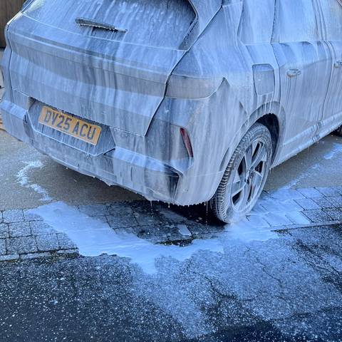 Black electric SUV covered in snow foam