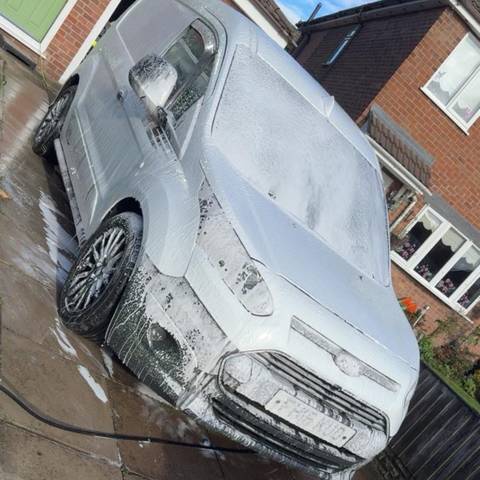 White Ford Transit Custom van covered in snow foam