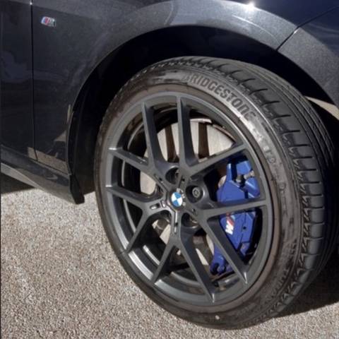 BMW M Sport alloy wheel with blue calipers after cleaning